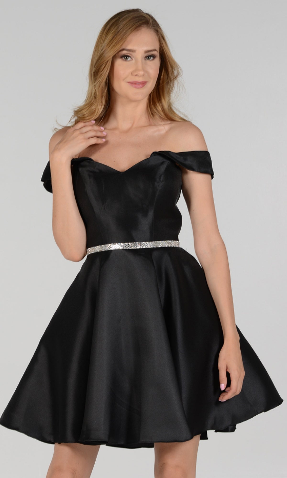 A woman models the Off-Shoulder Short Mikado Homecoming Dress 7948, featuring a flared skirt and silver belt, against a plain light gray background.